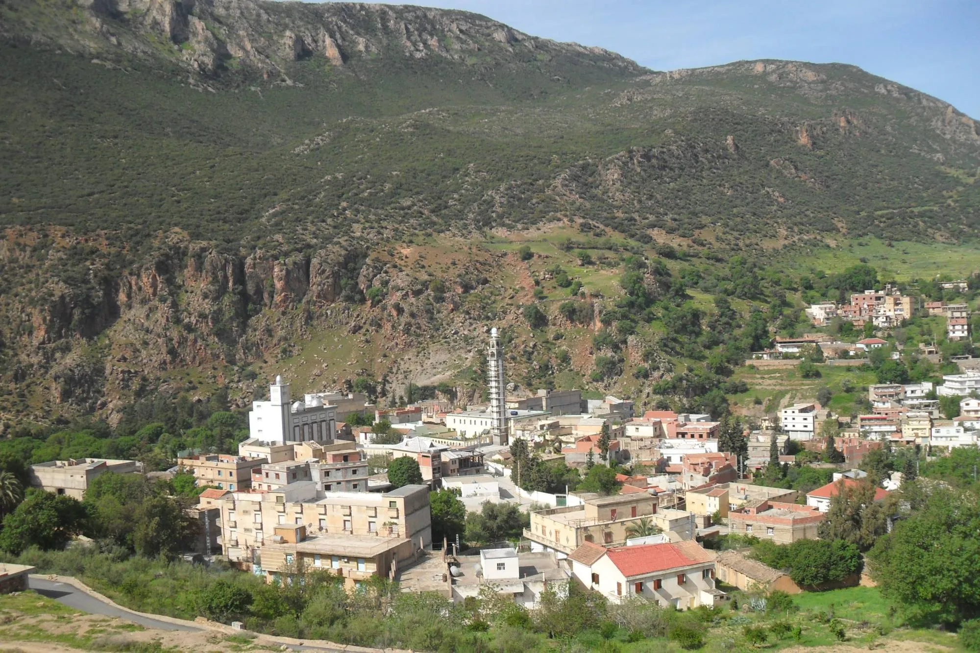 Une petite ville aux maisons claires et aux minarets blancs, au pied d’une montagne couverte de maquis et barrée de falaises rocheuses